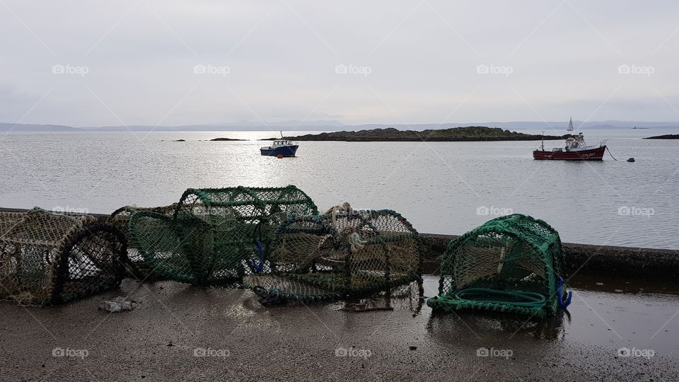lobster pots on pier, Isle of Jura, Scotland in sunset