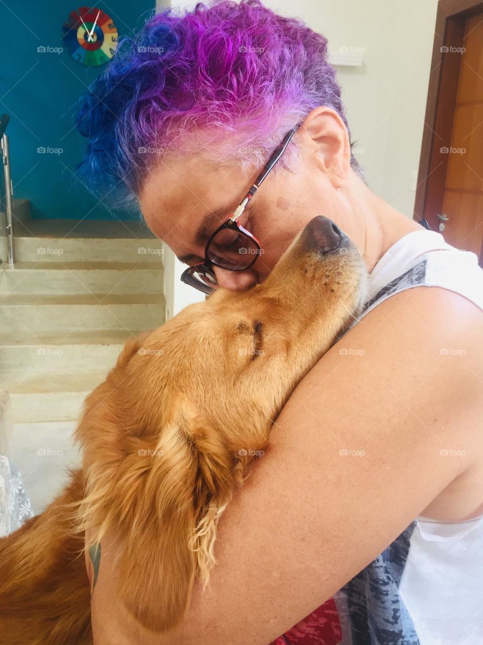 A golden retriever and her human hug each other in a moment of love and care. Happiness is in the air!