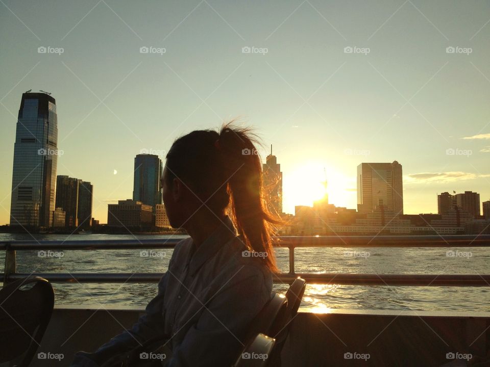 On tre circle line,Manhattan. A woman is looking the sunset on circle line across Manhattan,New York 