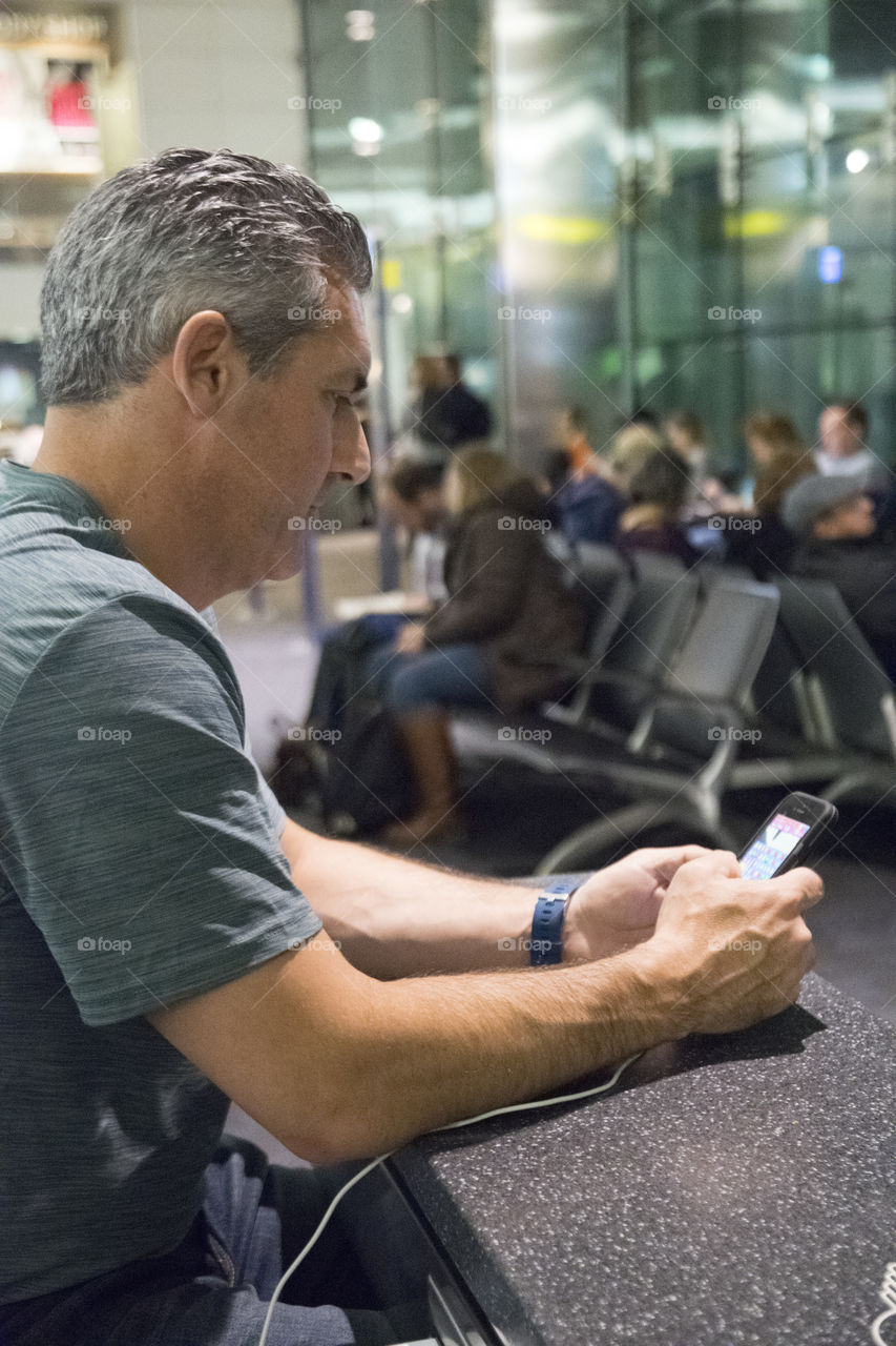 Man on his phone in the airport 