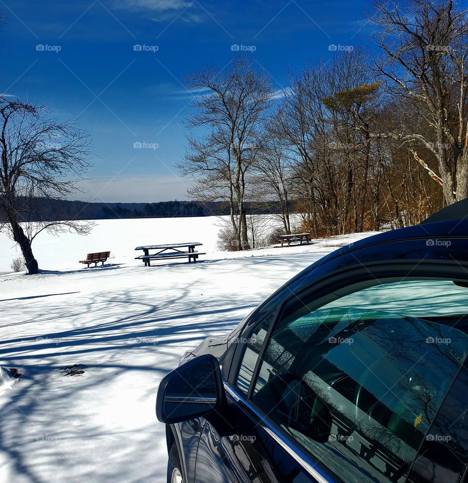 Car by a snow covered lake