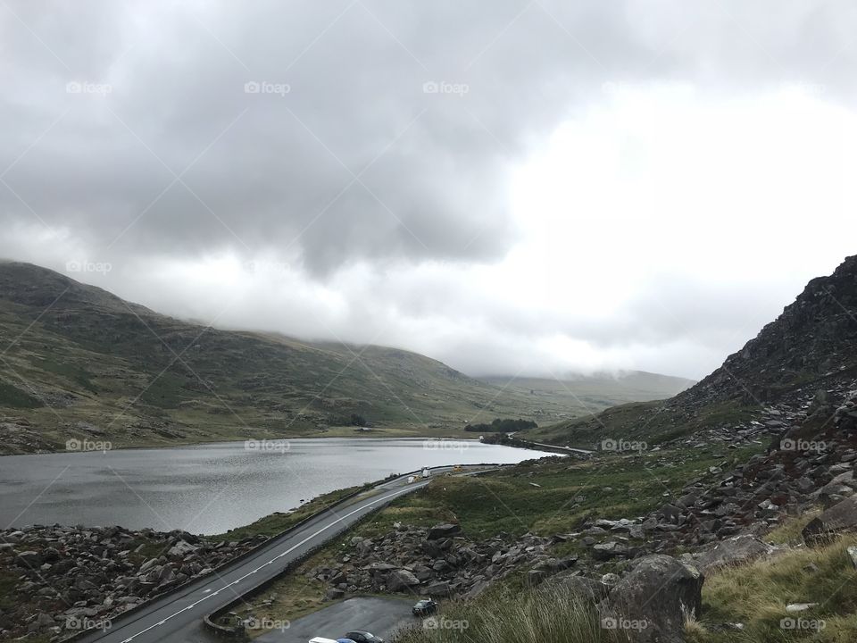 A winding road through the valley while the rain sets in