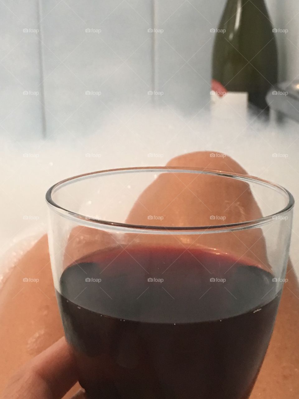 Point of view while relaxing with a good glass of red wine in the tub