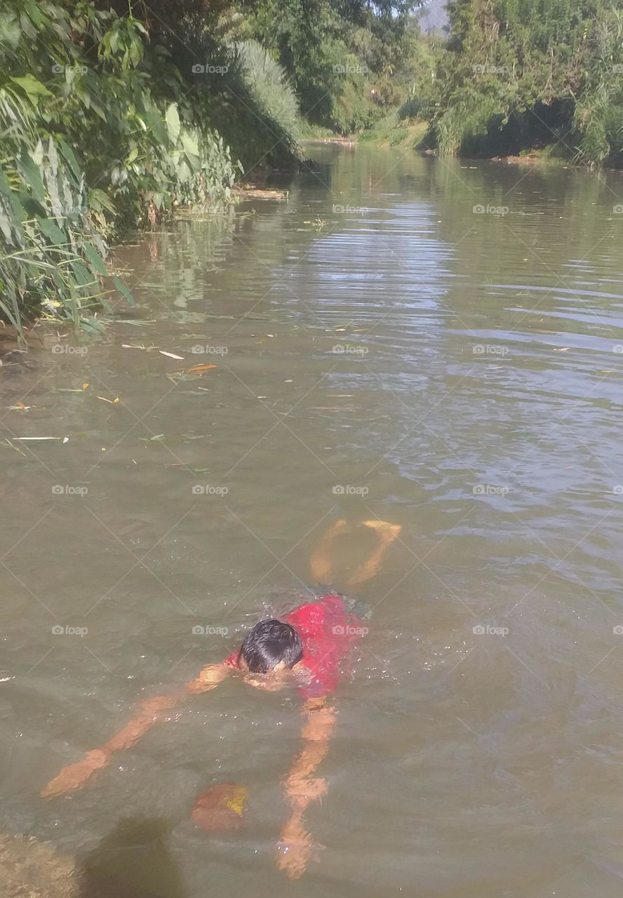 child swimming in river