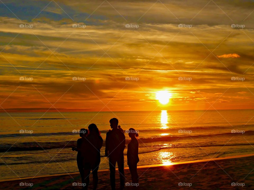 Family enjoying the sunset - Silhouettes are a wonderful way to convey drama, mystery, ... The perfect light for this is placing your subject in front of a sunset or sunrise – but really any bright light will be.