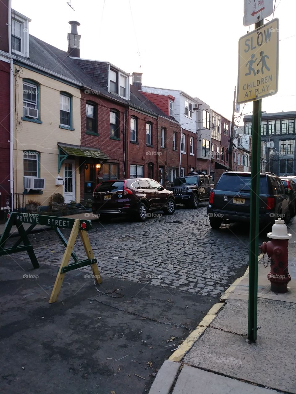 Urban remnants of the 19th century at dusk. Small row houses in Hoboken New Jersey on private cobblestone street.