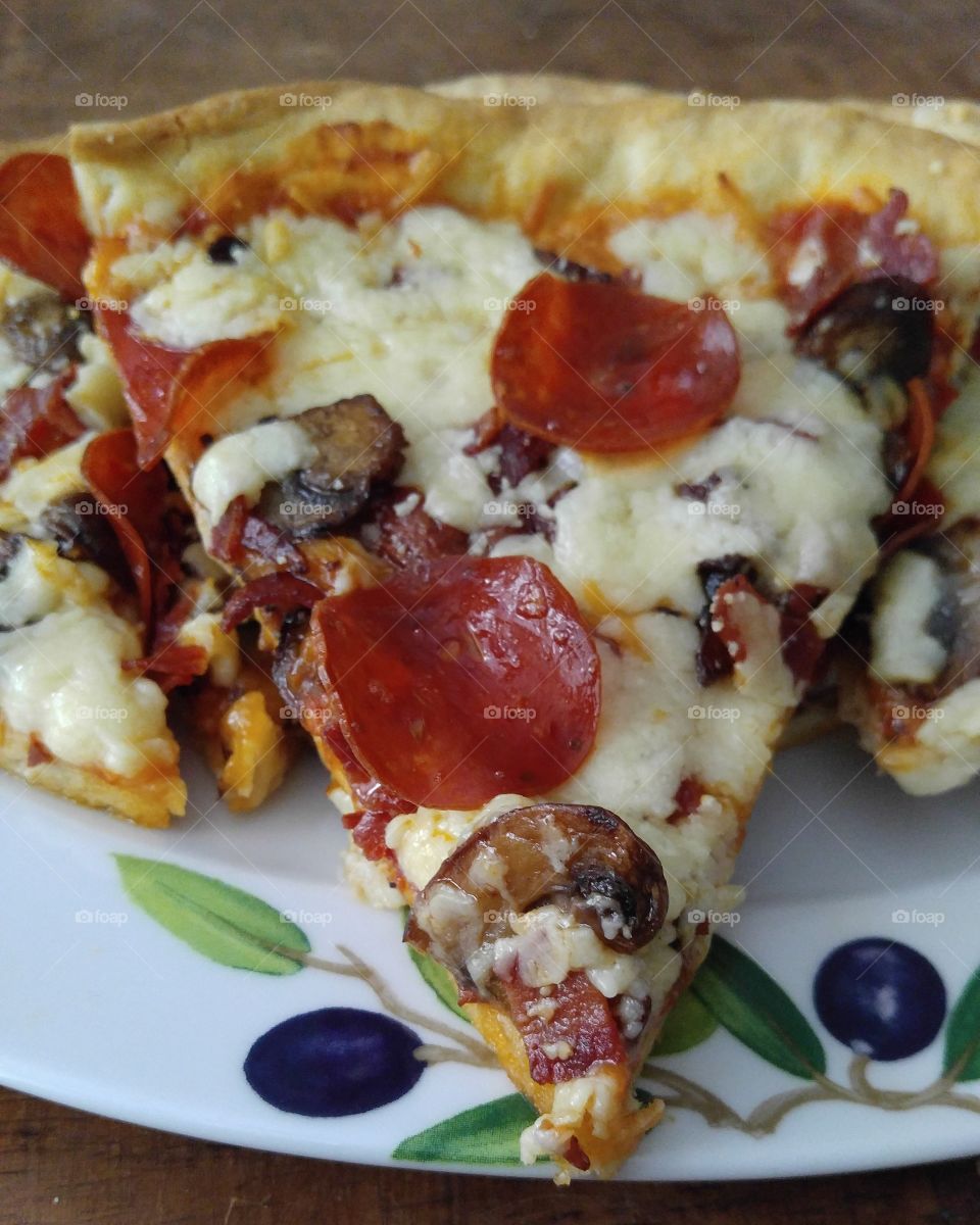 The joy of cooking. I made homemade pizza for dinner. Turkey bacon, mushrooms, white Sharp cheddar and pepperoni topped this delicious slice of heaven.