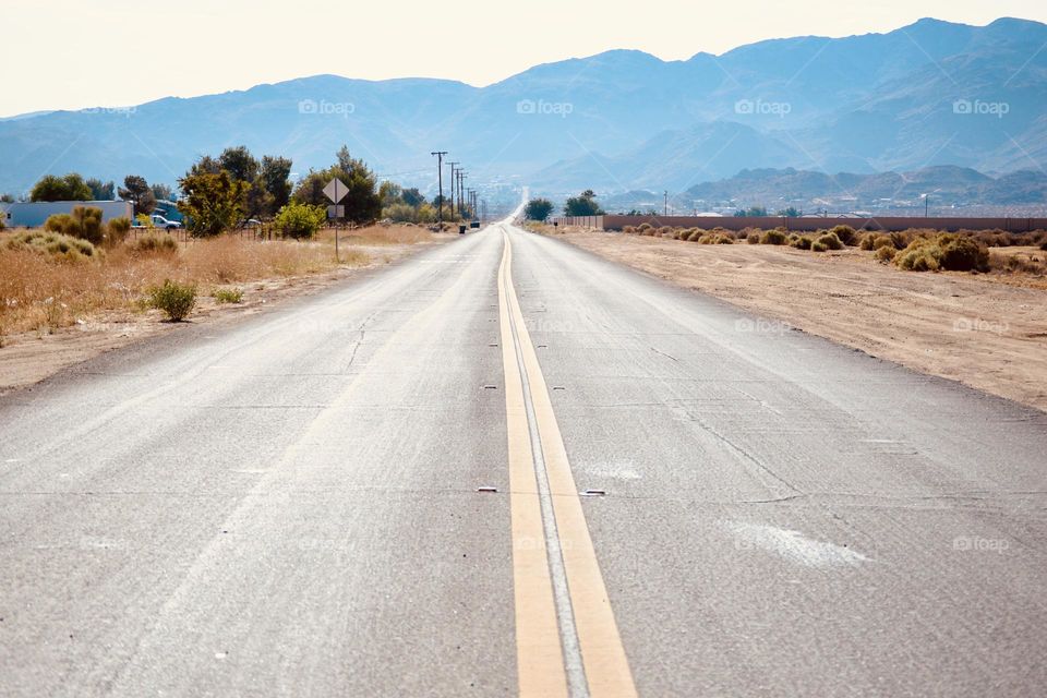 A deserted,quiet desert road right up the middle 