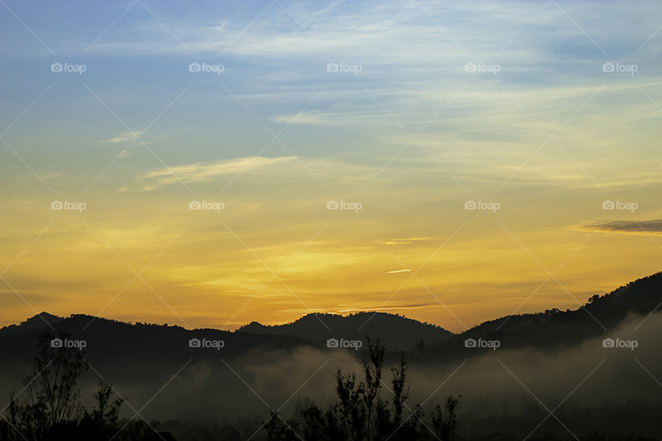 The morning sun light behind the mountains and the mist.