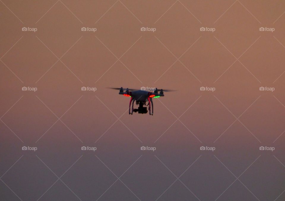 Quadcopter flying in the sky in the dawn