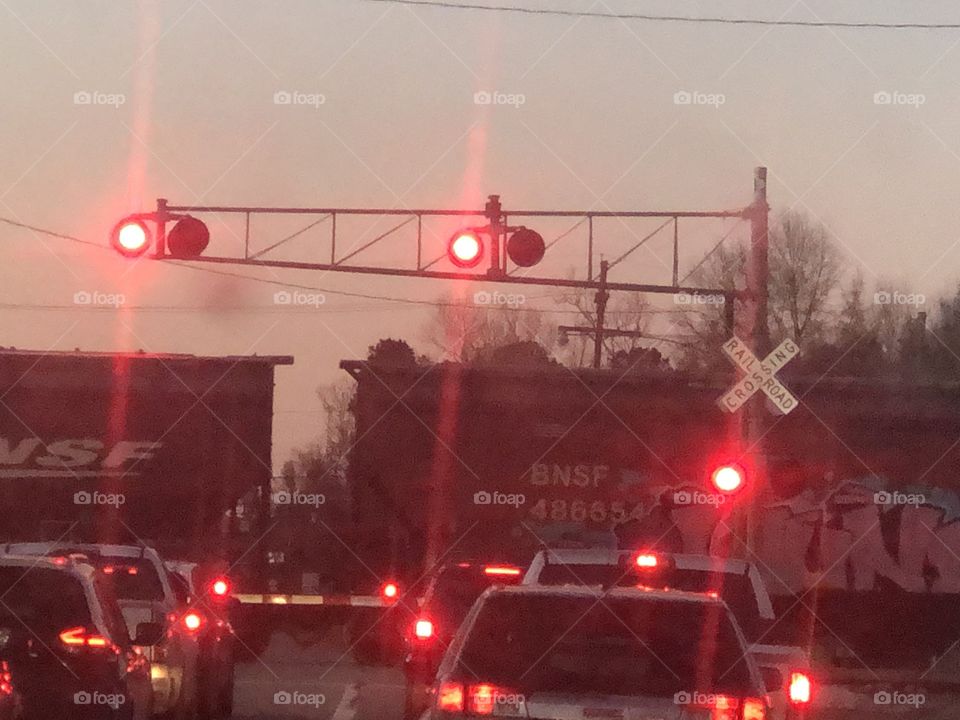 Train, train crossing, crossing, light, lights, warning, red, dusk, railroad, railway, rail, boxcar, boxcars, traffics, stopped, stopping, moving, 