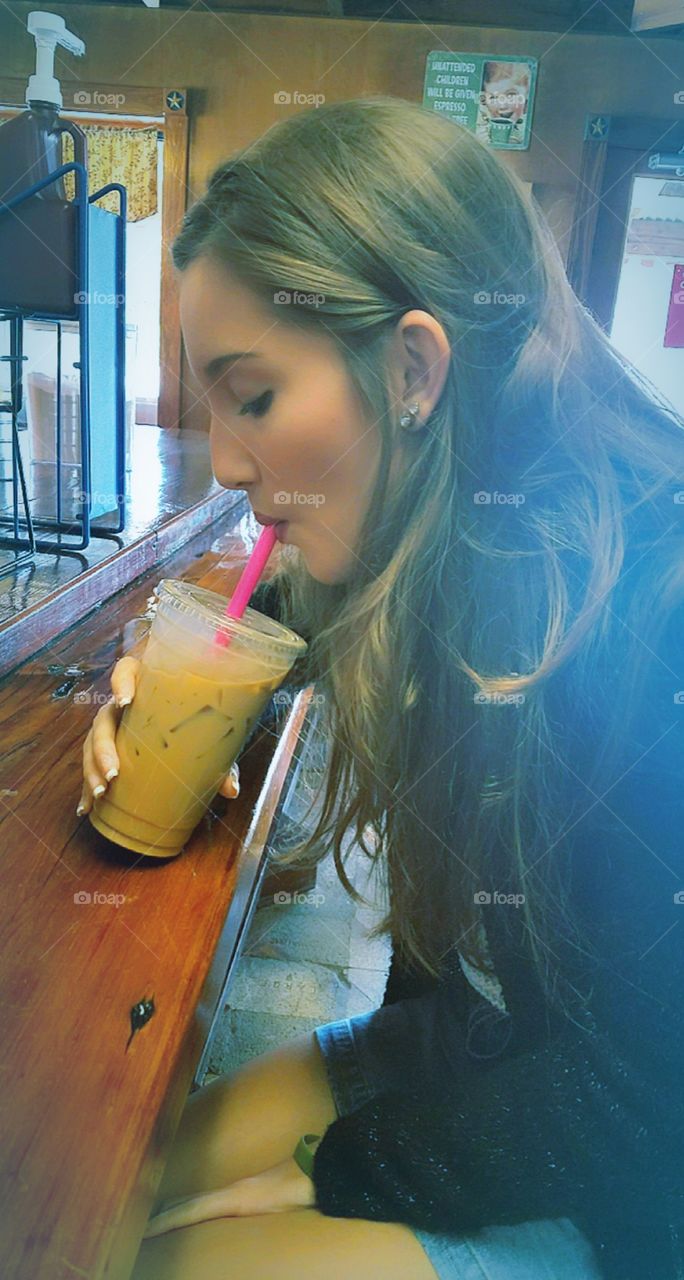 beautiful young girl drinking a cup of delicious coffee