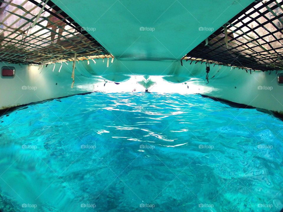 Under a sailboat. Blue skies,water and an awesome sailboat