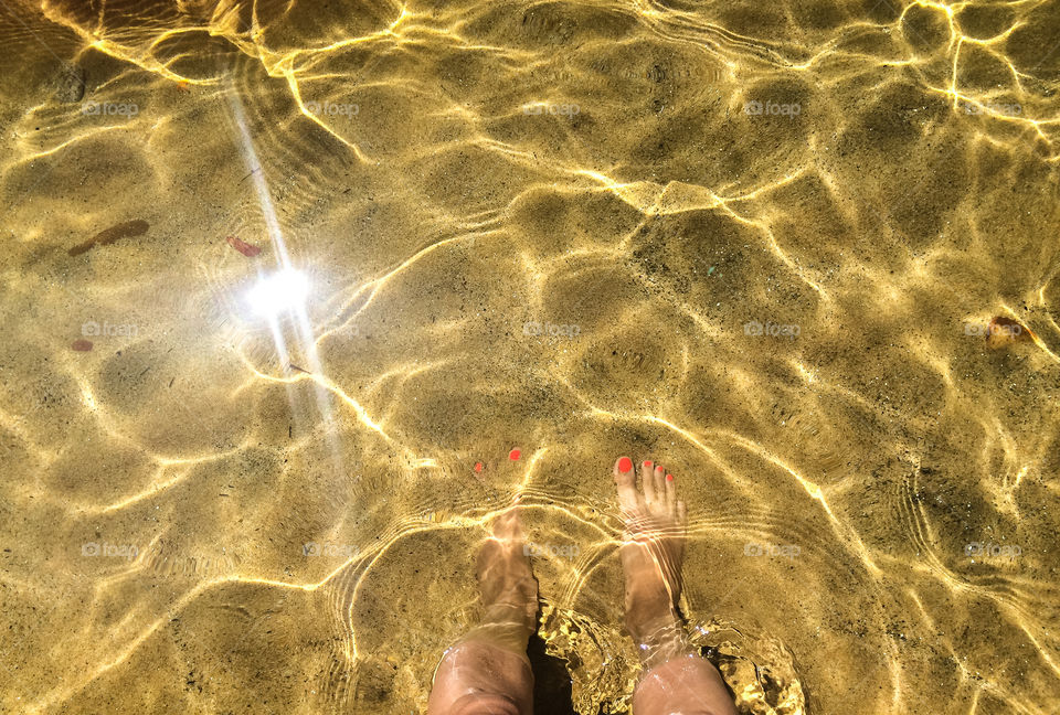 Female feet on the sand beach