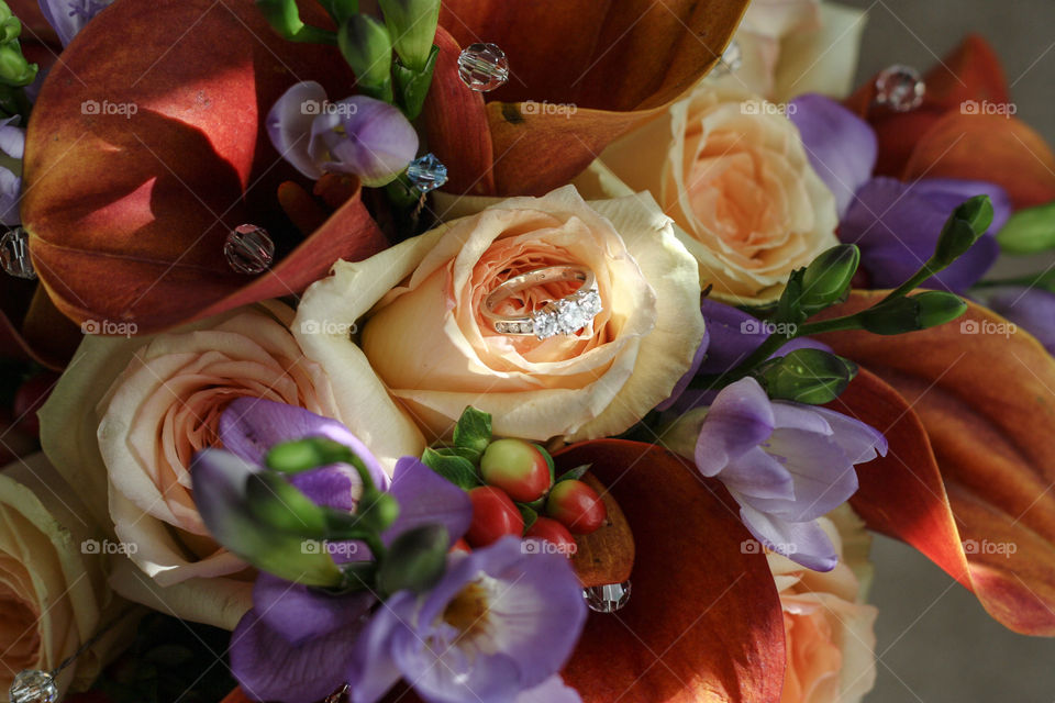 A bride's engagement ring set inside a colourful bouquet