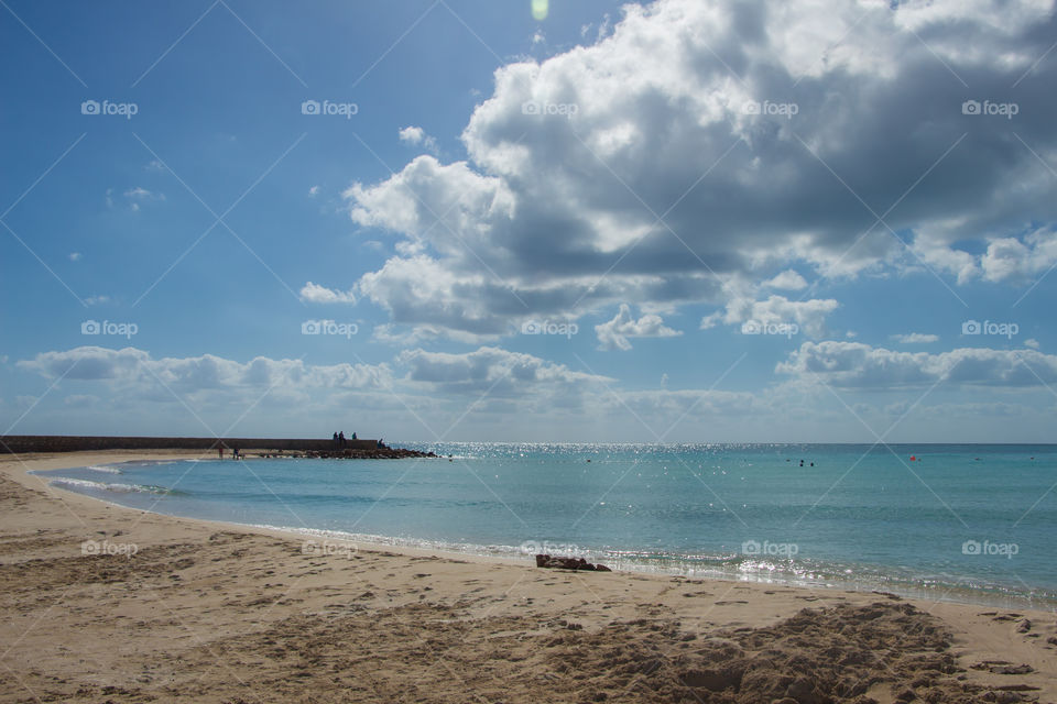 The beach in the morning. the sea the sand the sun and the clouds.