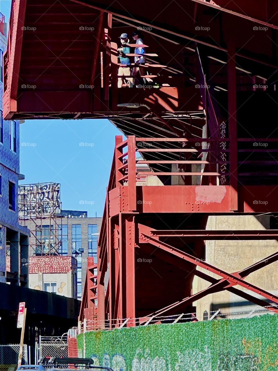 This is the red metal staircase of the “Pulaski Bridge” at “Newtown Creek” in “Greenpoint”, Brooklyn. The modern architectural style reminds in many ways of the “Bauhaus” design school in “Weimar”, Germany of the 1930s. 2024. Hypnotic Productions