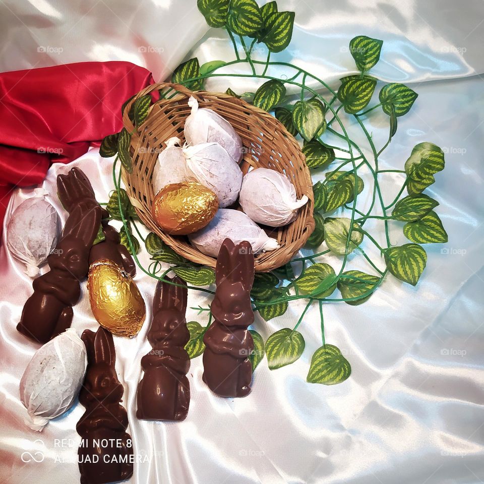 foto caseira com chocolates também caseiro tirada no domingo de Páscoa, coelho de chocolate e ovos pequenos tamanho 50 de chocolate ao leite .