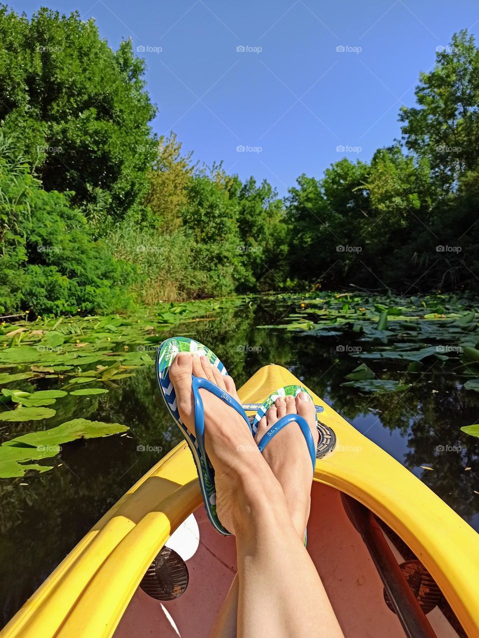 feet in flip flops on the bow of the kayak