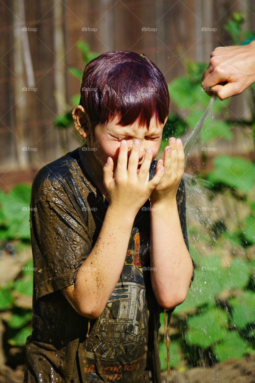 Boy Washing Mud Off His Face