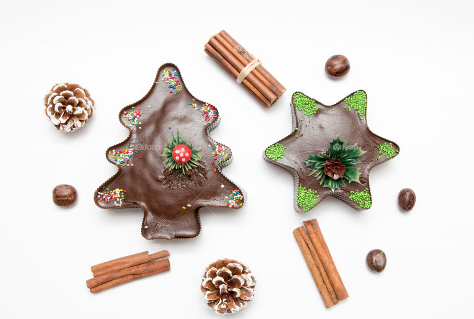 Composition Of Christmas Tree And Star Chocolate Muffin Cupcake, Pine Cones, Nuts And Cinnamon Isolated On White Background
