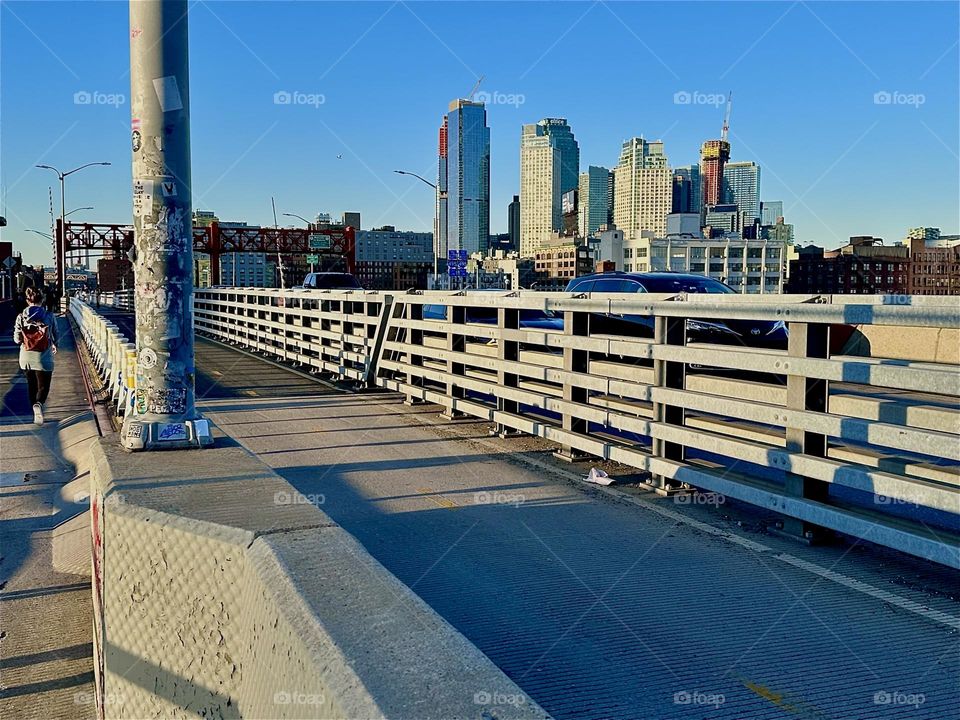 This is the pedestrian and bicycle lane of the “Pulaski Bridge” at “Newtown Creek” that connects “Greenpoint”, Bklyn to LIC in the direction that we are currently facing. The setting sun enhances the geometry of the bridge. 2024. Hypnotic Productions