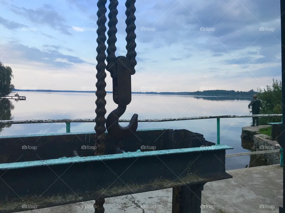 Metallic construction with hook and chain on the beautiful nature background 