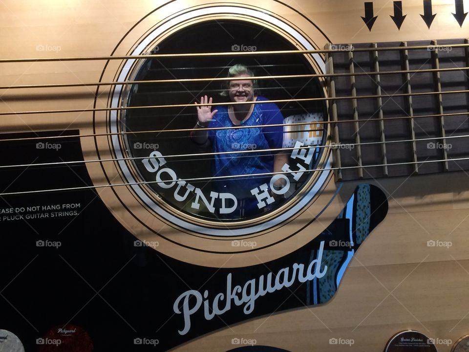 Funny portrait inside the sound hole of a guitar 