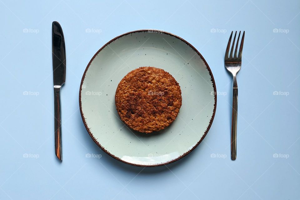 Top view of veggie burger on the plate against blue background close up