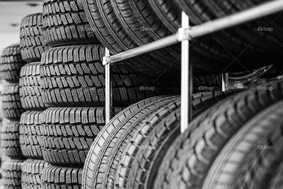 rack with variety of new car tyres in automobile store, selective focus