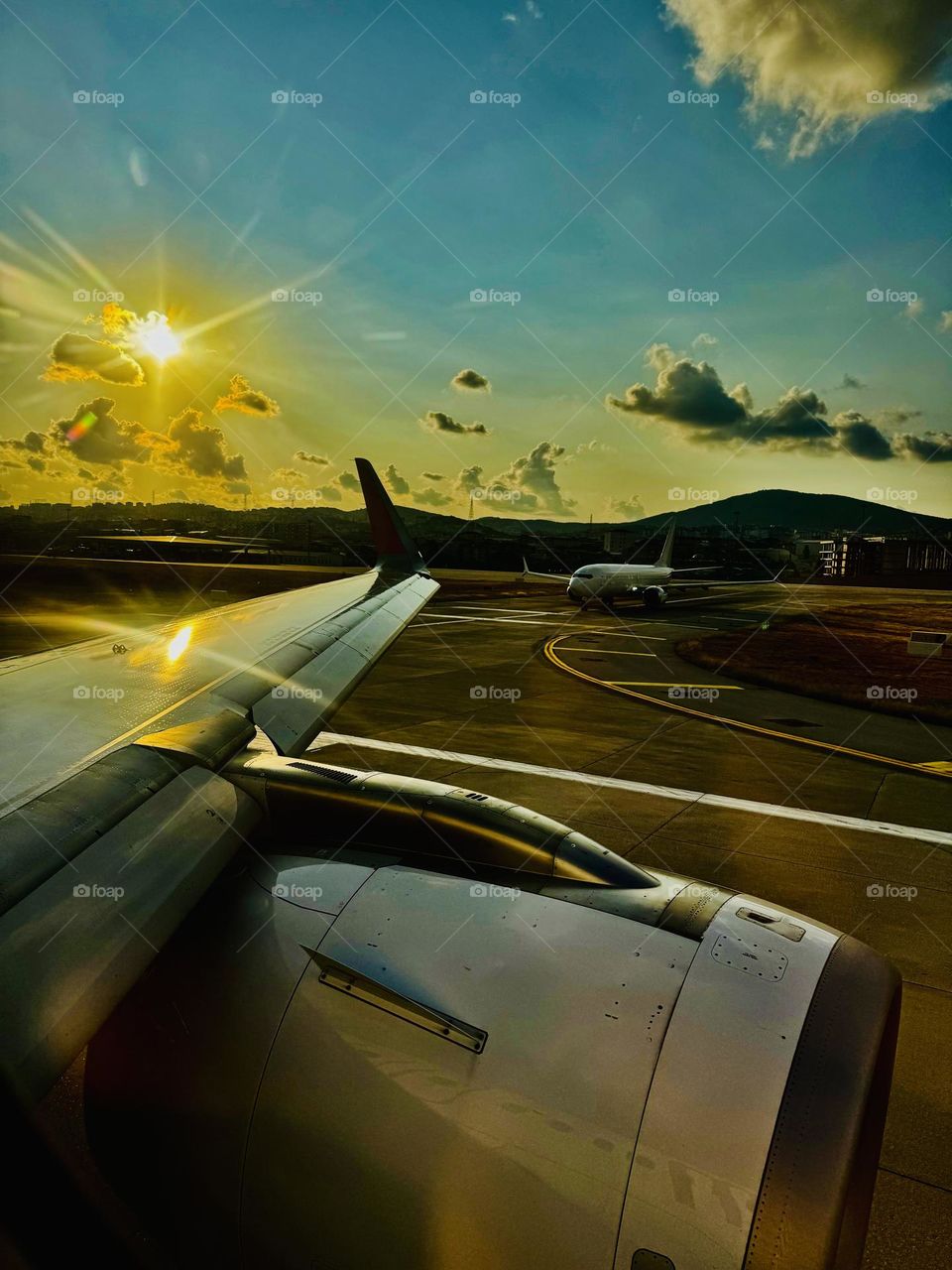 An airplane in the evening on the runway waiting for its turn.