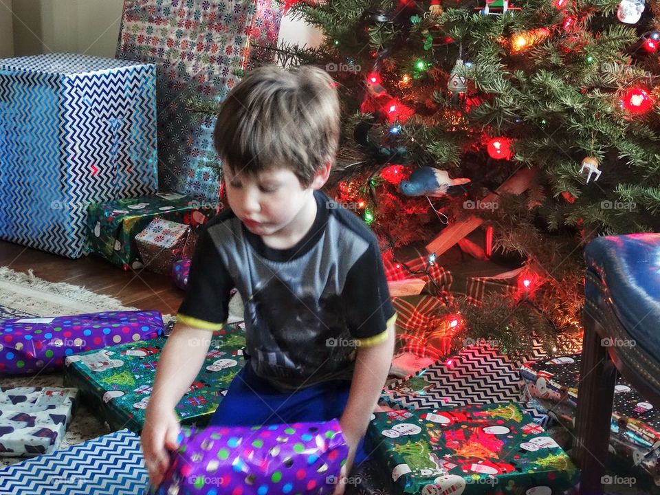 Opening Christmas Presents. Child With Gifts Under The Christmas Tree
