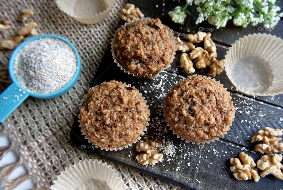 Healthy homemade oat bran muffins with walnuts on a dark wood board
