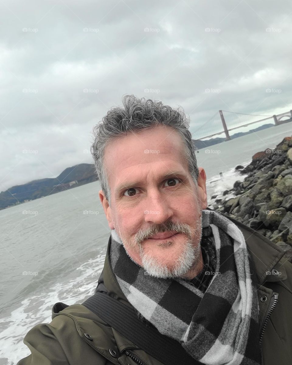 Enjoying a beautiful day on the San Francisco Bay with Golden Gate Bridge in the background, with the calm ocean and rocks