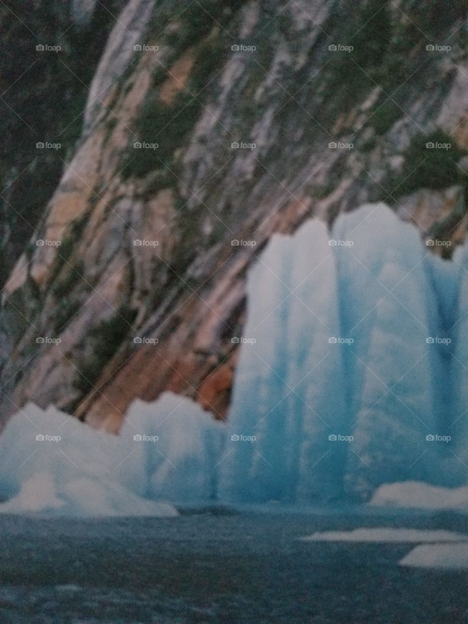 The iceberg is the main subject, but a sense of scale is lost in the balanced proportion. I composed tightly so the iceberg looms in the frame.