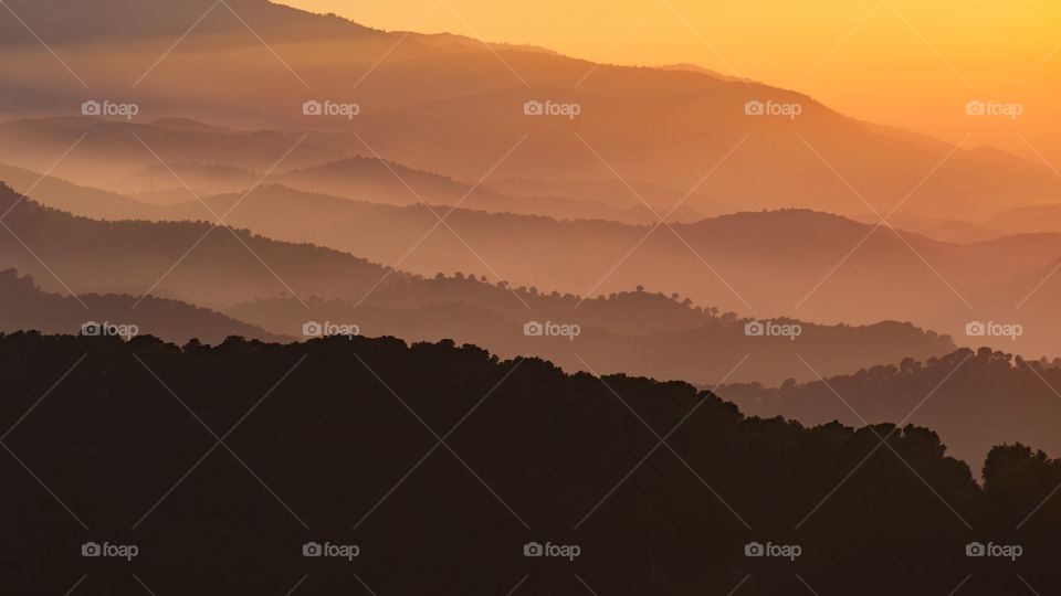 Mountain layers at a foggy sunset