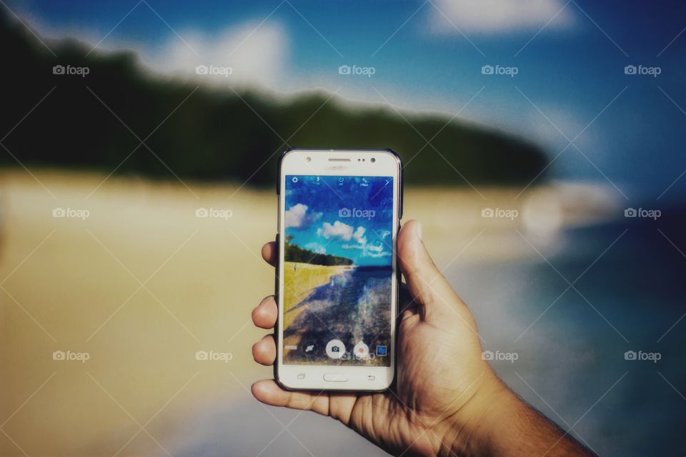 picture of a smartphone taking a photo of a beach in Mauritius island on a sunny day