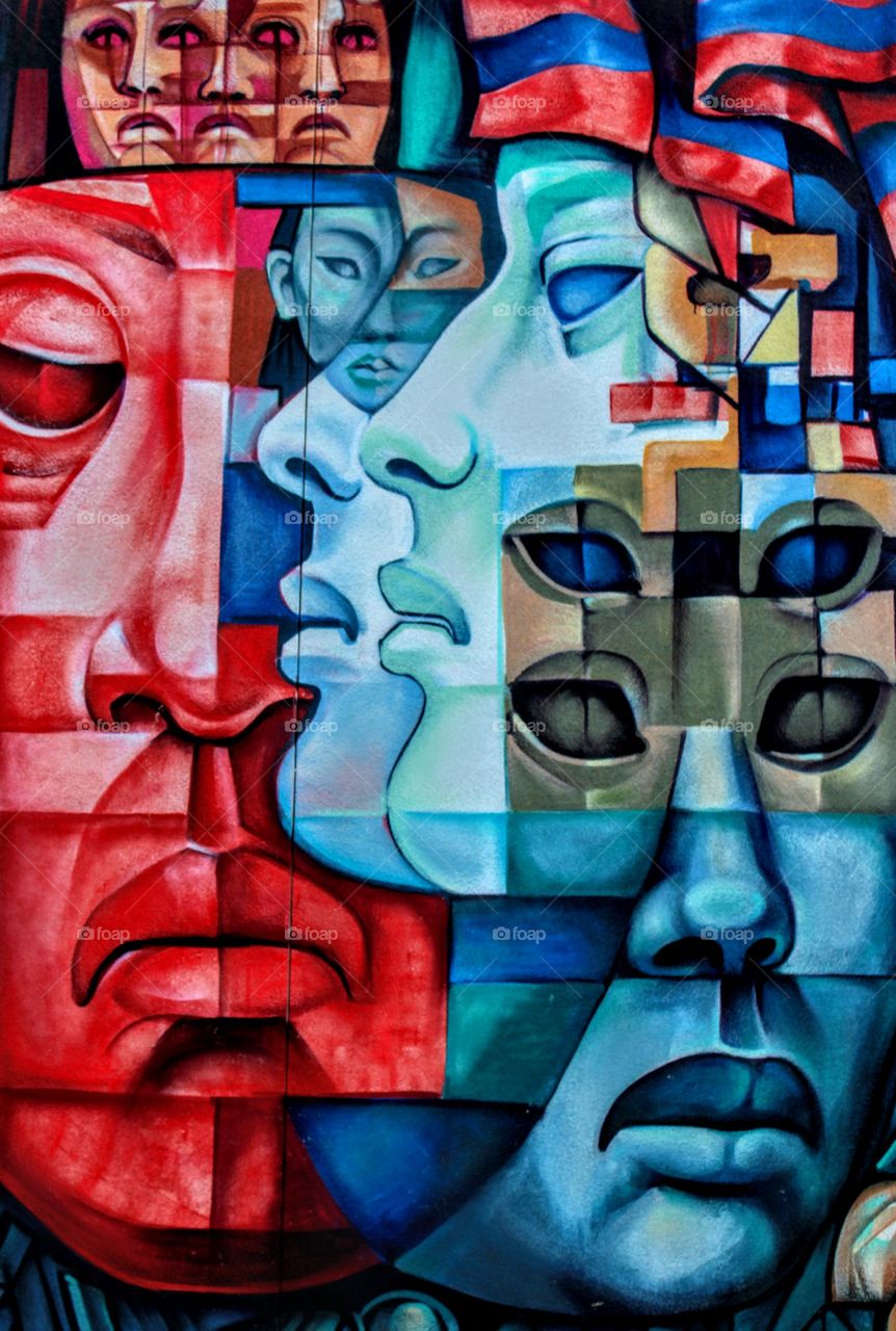I love these colors, graffiti art, blue is my favorite color. a painting on the side of a building of different colored faces