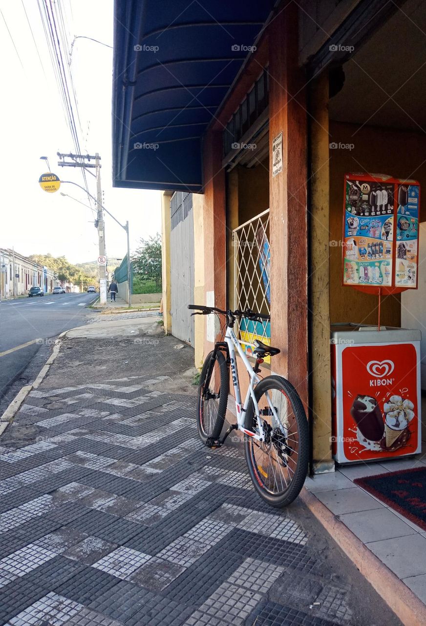 Bicycle on a sidewalk by a bakery