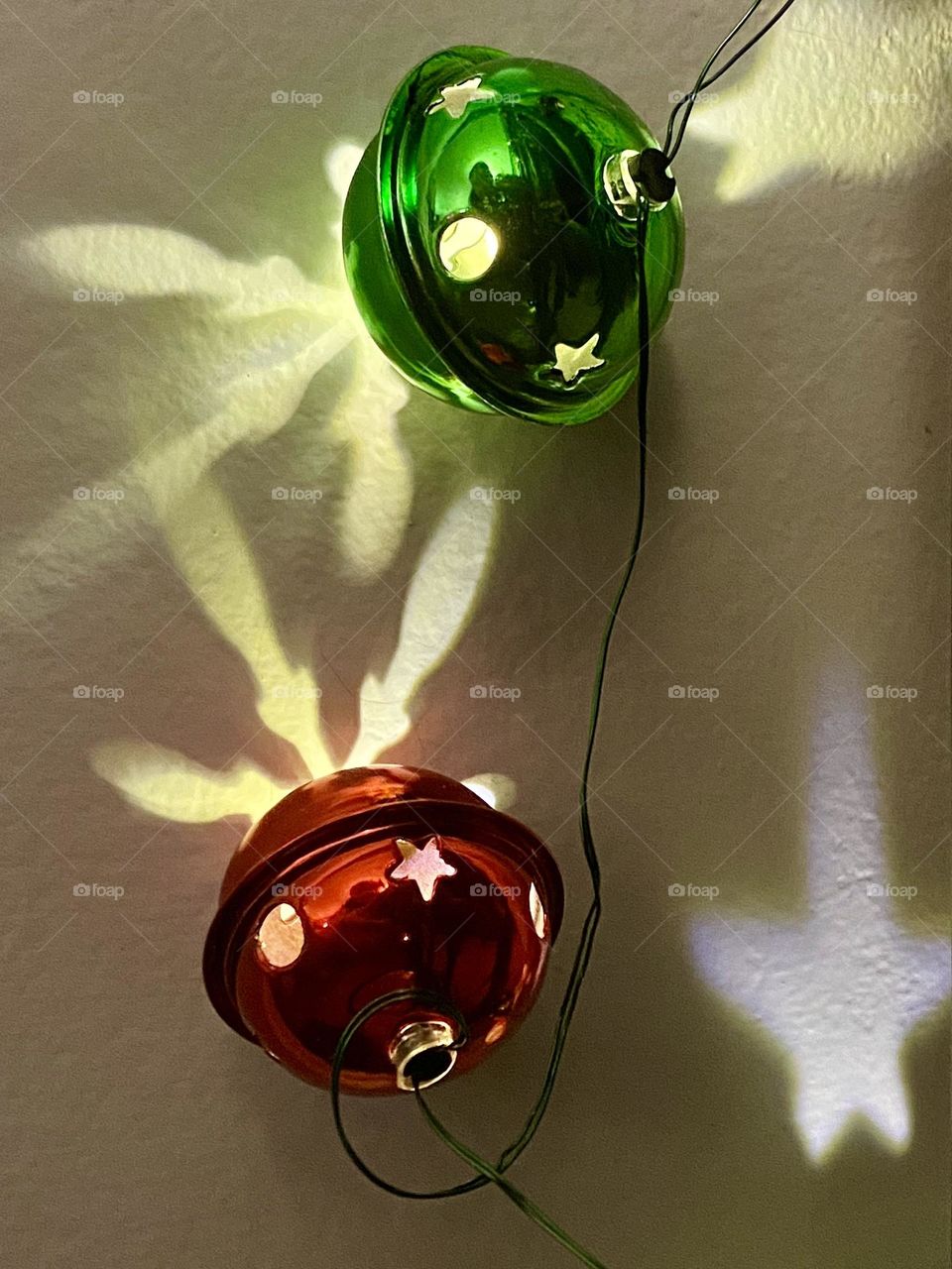 Red and green Christmas bell lights making reflections on a wall