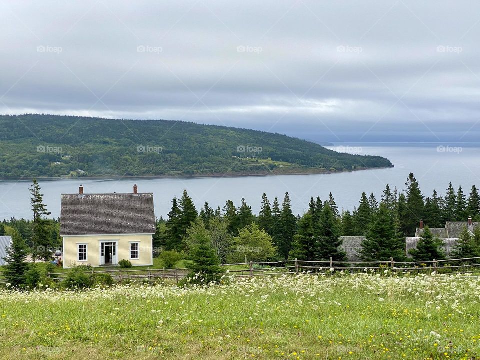 An old house sitting on a hill overlooking a waterway