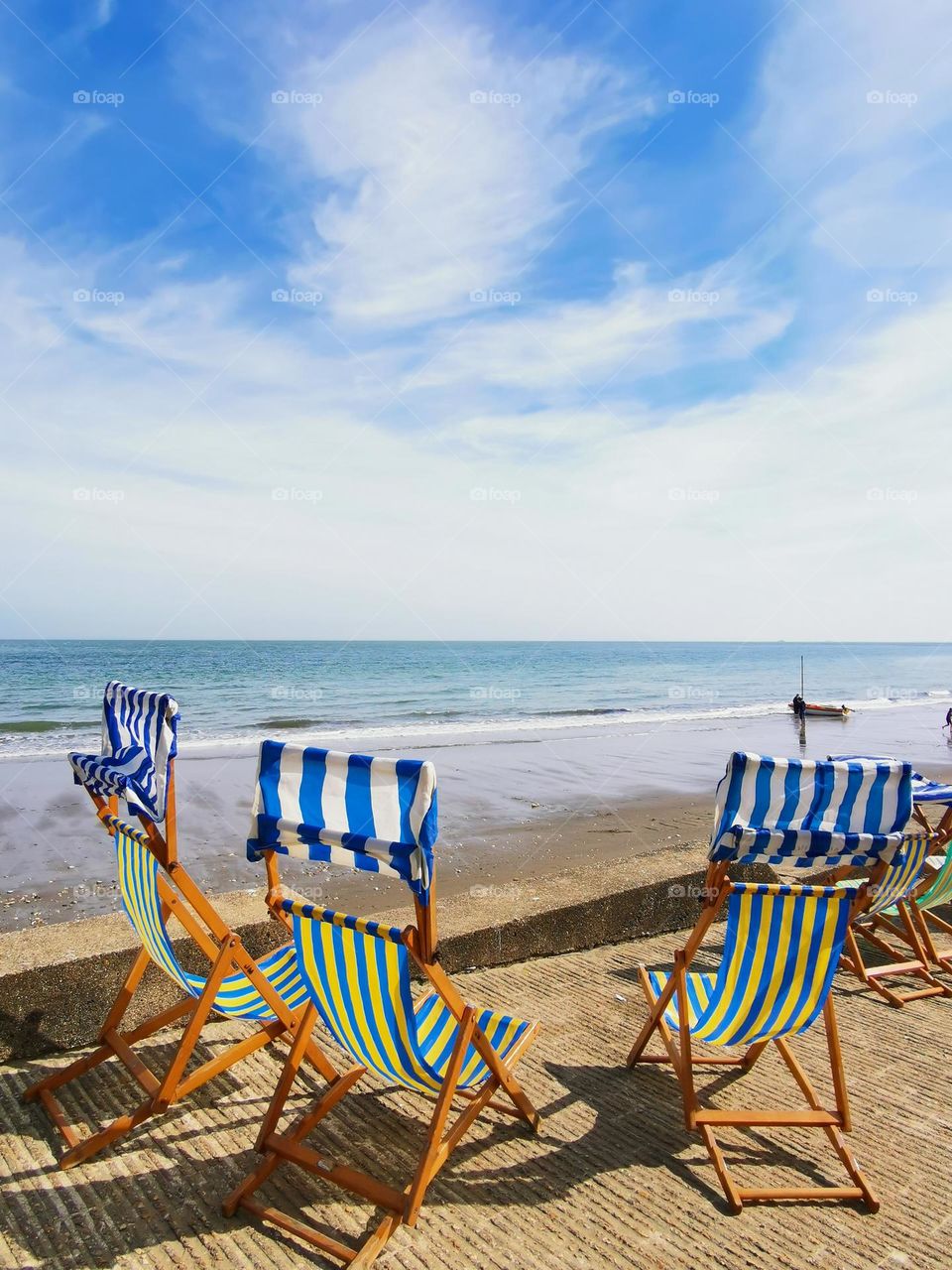 The first sunny spring days. Sea shore. Chairs for relaxation and sunbathing are waiting for vacationers. April in England. Beach. The beach season will start soon.