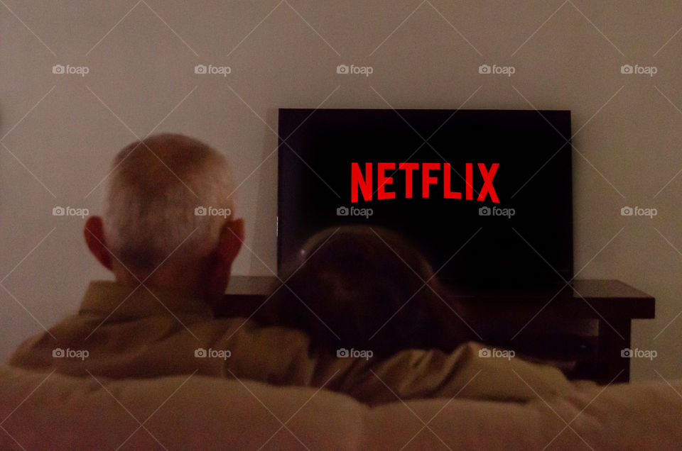 An elderly couple watching netflix.