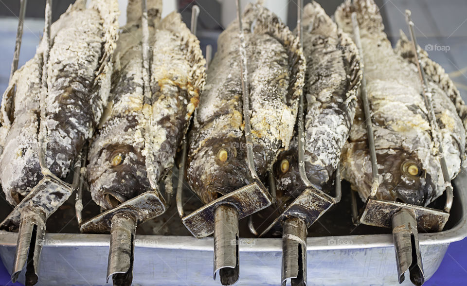 Tilapia fish with salt in the grill on the tray.