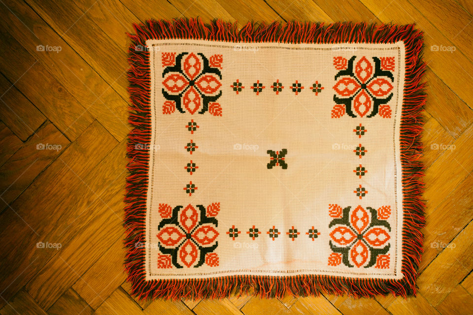 Traditional towel with red patterns on the parquet