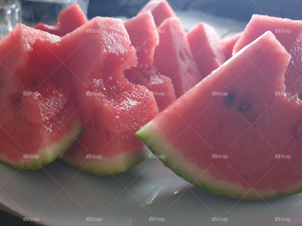 a close up portrait of slices of watermelon. the healthy fruit is ready to be eaten.