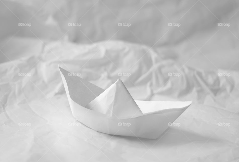 Whte paper boat on the white paper background