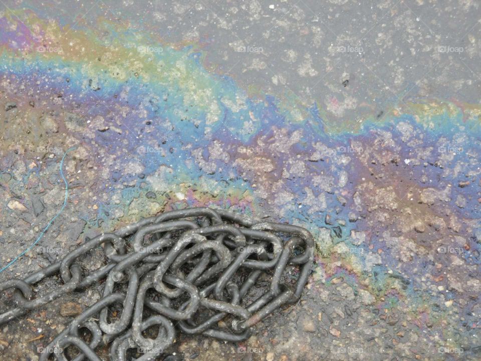 oil on water with old chain at the harbour at Penzance Cornwall UK