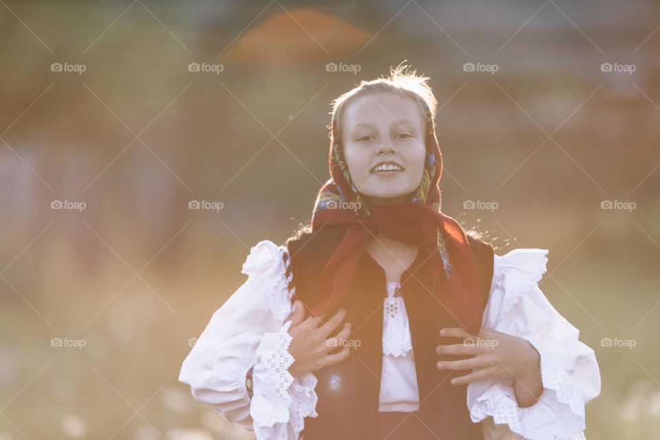 Beautiful young girl, smiling and being happy, wearing a traditional costume at a festival.