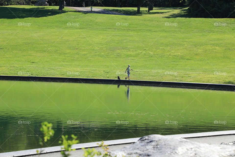 Man walking dog by lake